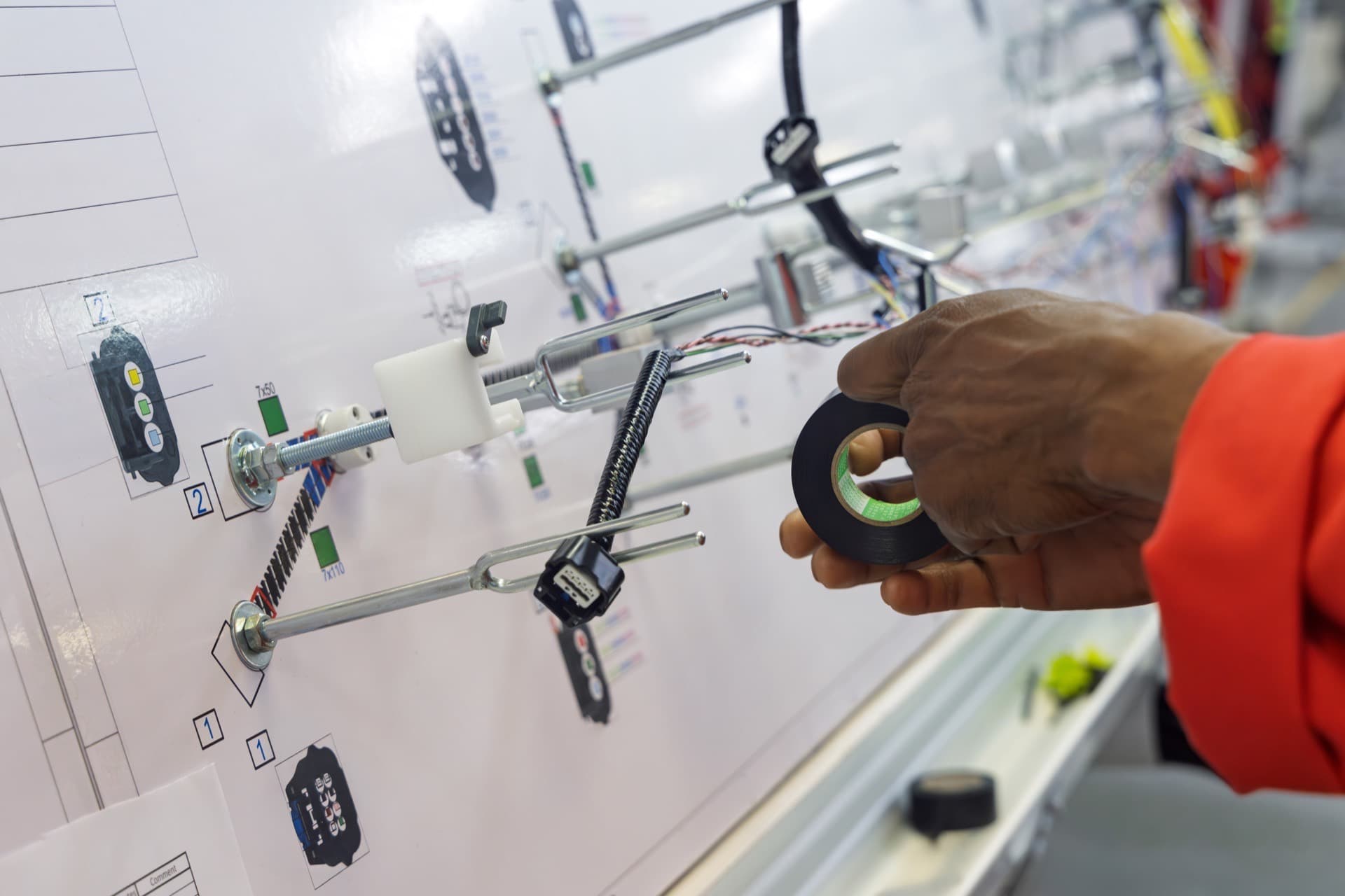 Technician building a prototype wire harness on a form board